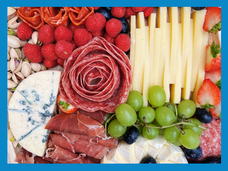 Grazing board with colourful fruit, cheese and charcuterie